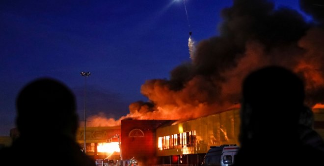 Gente observa el fuego desatado en un centro comercial en Moscú. /REUTERS