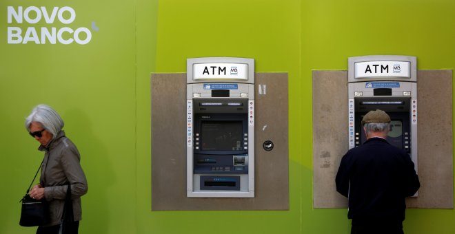 Varios clientes operan en los cajeros automáticos de una oficina de Novo Banco, en Lisboa