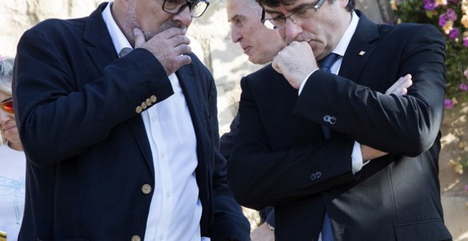 El presidente de la Generalitat, Carles Puigdemont (d), conversa con el presidente del grupo parlamentario de Junts pel Sí (JxSí), Lluís Corominas, tras la tradicional ofrenda ante la tumba del presidente de la Generalitat republicana Lluís Companys coinc