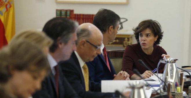 La vicepresidenta del Gobierno, Soraya Sáenz de Santamaría, conversa con el ministro de Justicia, Rafael Catalá, junto al ministro de Hacienda y Función Pública, Cristóbal Montoro, y el ministro de Fomento, Íñigo de la Serna, al inicio hoy de la reunión e