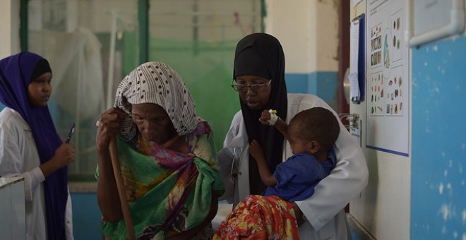 Una enfermera del hospital de Banadir en Mogadiscio, Somalia, ayudó a una anciana, que llevó a su nieto desnutrido al hospital a recibir tratamiento para la desnutrición. AMISOM Photo / Tobin Jones