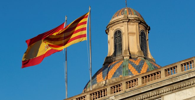 La bandera española y catalana ondean en lo alto del Palacio de la Generalitat en Barcelona.REUTERS/Yves Herman