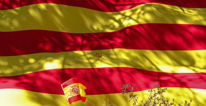 Una bandera española sobre una senyera, en una manifestación en Barcelona el pasado 29 de octubre. REUTERS