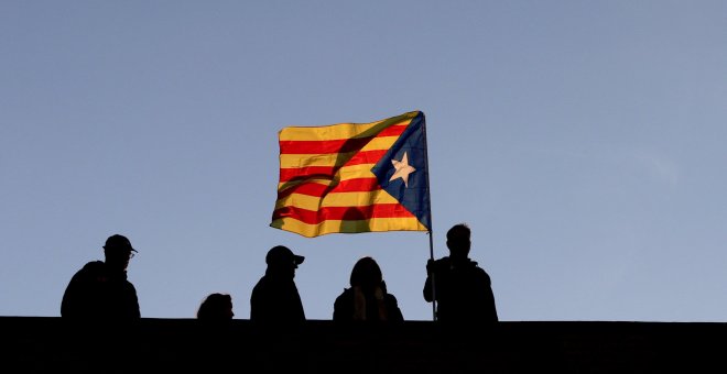 Varios vecinos ondean una senyera en una terraza durante la manifestación convocada en Barcelona por la ANC y Ómnium para exigir la libertad de los 'Jordis' y los miembros del Govern cesados y encarcelados por orden de la Audiencia Nacional. EFE/Alberto E