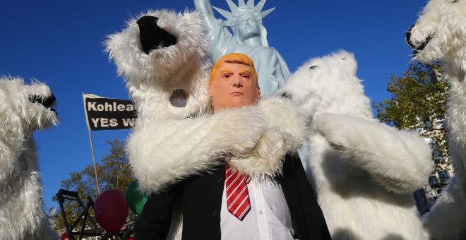 Un manifestante vestido con una máscara del presidente de EEUU Donald Trump junto a otros manifestantes disfrazados de osos polares, durante una manifestación de organizaciones ecologistas en Bonn, ante la cumbre del  clima COP23. REUTERS / Wolfgang Ratta