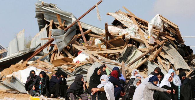 Mujeres sentadas ante sus hogares demolidos en el pueblo beduino de Umm al-Hiran, en el desierto israelí de Negev. / REUTERS