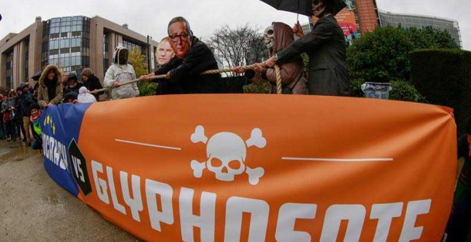 Activistas se congregan con máscaras del presidente de la Comisión Europea, Jean-Claude Juncker, y otros comisarios, en protesta contra el herbicida glifosato frente a la sede de la Comisión Europea en Bruselas. | OLIVIER HOSLET (EFE)