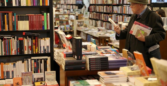 Una hombre hojea unos libros hoy en la librería la Central de Barcelona, en el Día de las Librerías.- EFE