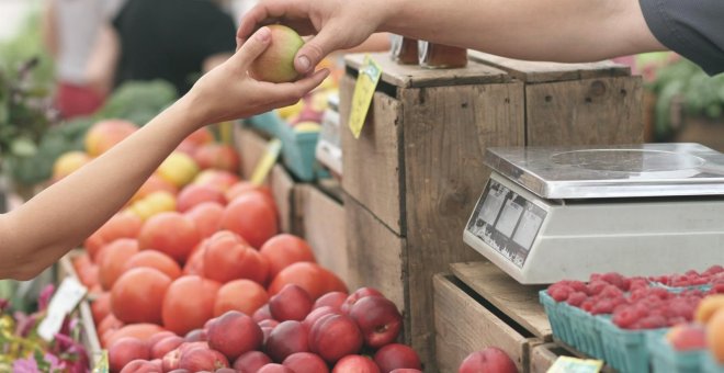 Una mujer compra en un puesto de frutas en un mercado. E.P.
