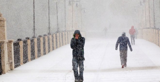 Varias personas entre la nieve en una calle de Teruel. EFE