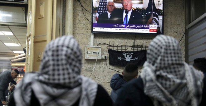 Palestinos escuchan el discurso de Trump en el que reconoce oficialmente a Jerusalén como capital de Israel. REUTERS/Ammar Awad