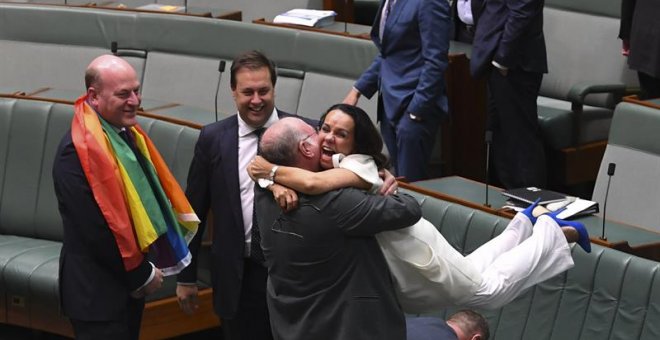l diputado liberal Warren Entsch (c-i) coge en brazos a la diputada Linda Burney (c-d) mientras celebran la aprobación del matrimonio entre personas del mismo sexo en el Parlamento en Canberra (Australia) hoy, 7 de diciembre de 2017. El Parlamento austral