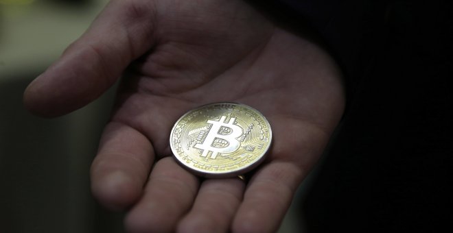 Un hombre enseña una moneda representativa de Bitcoin, en Moscú (Rusia).. EFE/Maxim Shipenkov