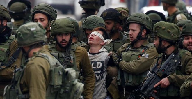 Soldados israelíes detienen a un manifestante durante unas protestas contra la decisión del presidente estadounidense, Donald Trump, de reconocer a Jerusalén como capital de Israel, en la ciudad cisjordana de Hebrón (Palestina).- EFE/ Abed Al Hashlamoun