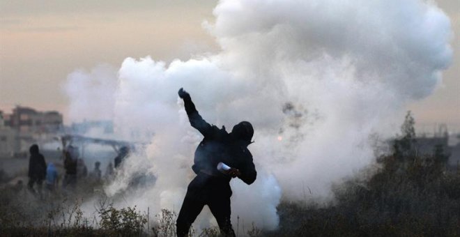 Un manifestante palestino devuelve una granada de gas israelí durante enfrentamientos cerca a la frontera con Israel. EFE/MOHAMMED SABER