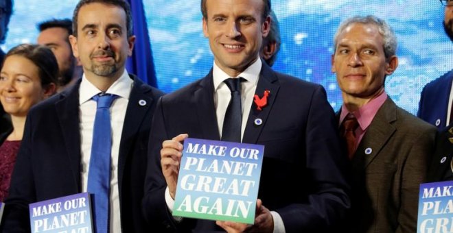 El presidente francés, Emmanuel Macron, en la cumbre One Planet Summit, con un cartel que dice "Make our planet great again".