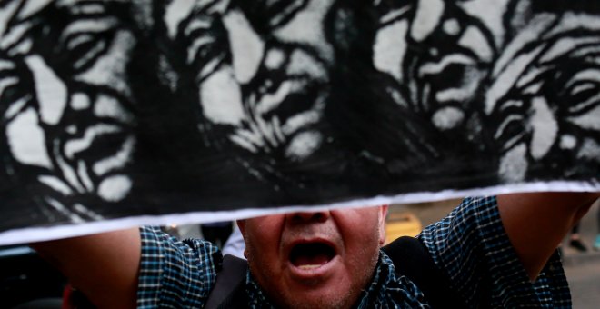 Un activista mapuche sujeta una pancarta durante las protestas por la muerte de Rafael Nahuel en Santiago, Chile./REUTERS
