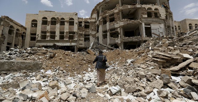 Un Houthi camina a través de los escobros tras los ataques aéreos liderados por Arabia Saudí en Yemen (2015). REUTERS /Khaled Abdullah