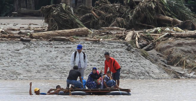 Un grupo de personas se pone a salvo de las riadas provocadas por la tormenta Tembin en Filipinas./REUTERS