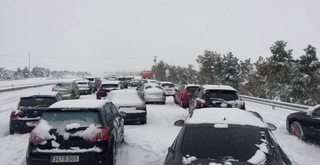 Fotografía facilitada por un conductor retenido en la A-6, a la altura del Km 75, en sentido Madrid. Familias atrapadas en sus coches por la nevada en la AP6 han pasado la noche en sus coches a la espera de que las máquinas quitanieve puedan desbloquear l