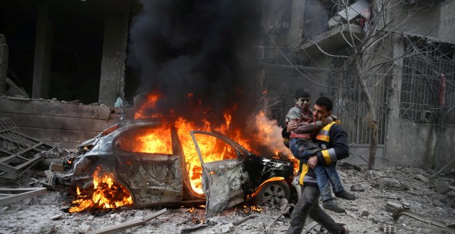 Un miembro de la Defensa Civil de Siria porta a un niño herido en Hamoria, Ghouta Oriental, Damasco. / Reuters