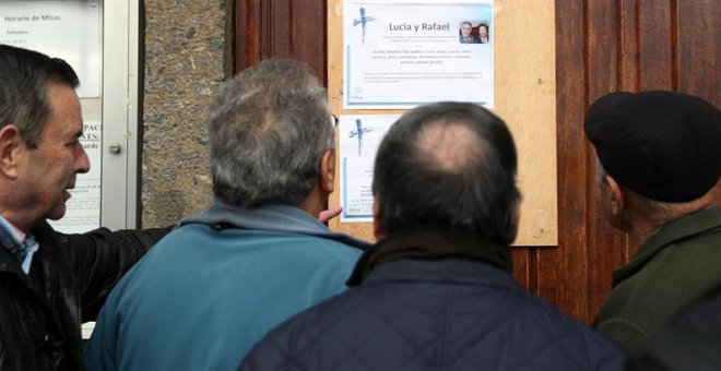 Vecinos de los fallecidos observan la esquela de los dos ancianos asesinados en Bilbao. / LUIS TEJIDO (EFE)