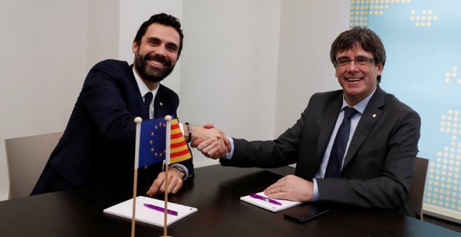 Roger Torrent y Carles Puigdemont se saludan al inicio de su reunión en Bruselas. | YVES HERMAN (REUTERS)