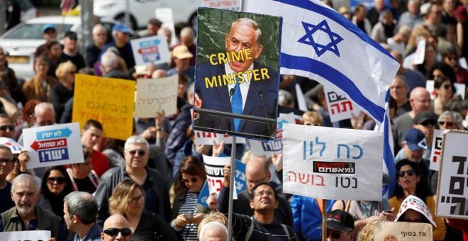 Varios manifestantes protestan contra la corrupción gubernamental y reclaman la dimisión del primer ministro israelí, Benjamin Netanyahu, en la plaza Habima de Tel Aviv, Israel. EFE/ Abir Sultan