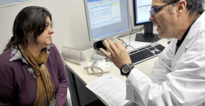 Un doctor en una consulta médica con una paciente. EFE