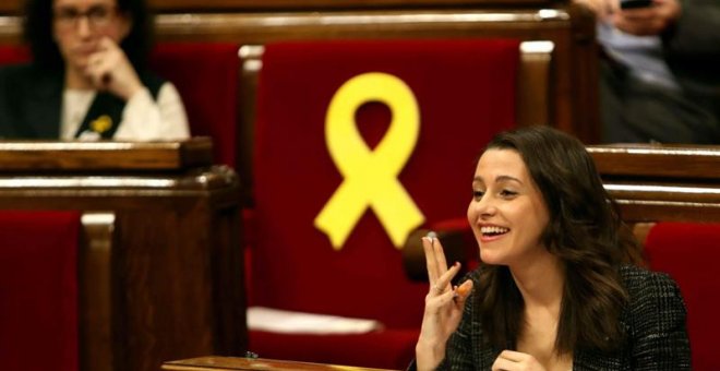 La líder de C's al Parlament, Inés Arrimadas, amb la número 2 d'ERC, Marta Rovira, en segon pla, al costat d'un llaç vermell a l'escó bit que correspon a Oriol Junqueras, en el ple d'aquest dijous. EFE / Toni Albir