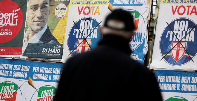 Un hombre junto a varios carteles electorales en la localidad de  Pomigliano D'Arco, cerca de Nápoles. REUTERS/Alessandro Bianchi