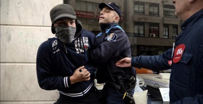 Un policía local reduce a un joven integrante de un piquete informativo en Ourense. EFE