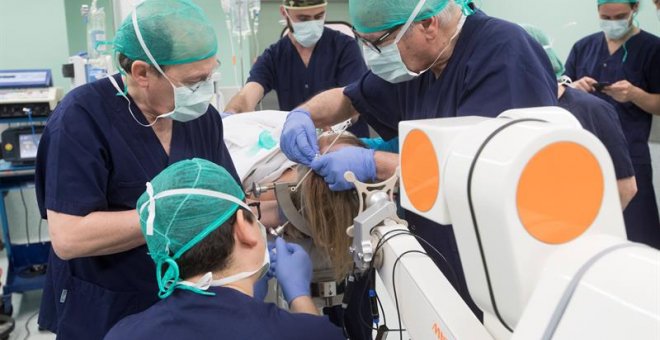Neurocirujanos operan con un robot a la enferma de párkinson. / MARTA PÉREZ (EFE)