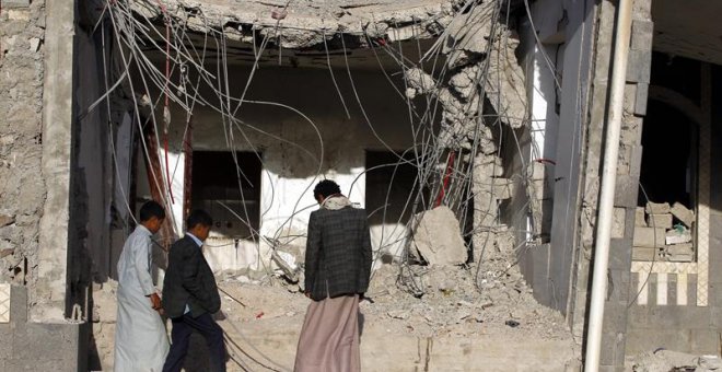 Una familia yemení frente a los escombros de un edificio presuntamente destruido por los recientes ataques aéreos, en el tercer aniversario de la campaña militar encabezada por Arabia Saudita. EFE/EPA/YAHYA ARHAB