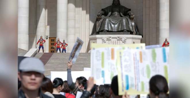 Los guardias de honor del Parlamento de Mongolia mientras miles de personas se manifiestan para exigir más acciones para prevenir el abuso infantil. / Reuters