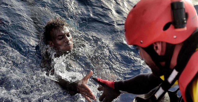 Un cooperante rescata a una persona migrante cuya embarcación ha naufragado en el Mediterráneo.- AFP/ARCHIVO