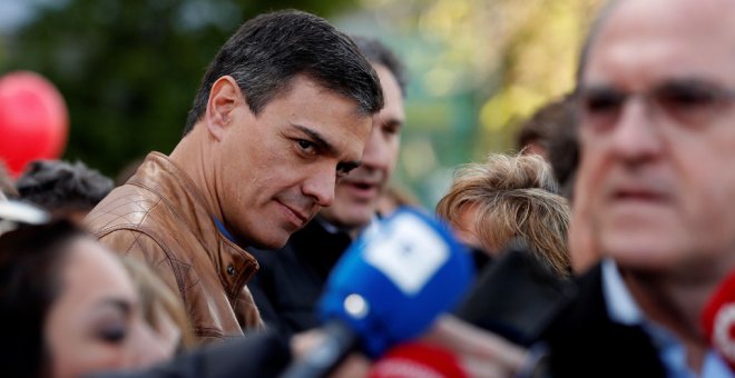 El secretario general del PSOE, Pedro Sánchez, observa al candidato socialista a la Comunidad de Madrid, Ángel Gabilondo, antes de su participación en la manifestación que se celebra en Madrid con motivo del Primero de Mayo. EFE/Chema Moya