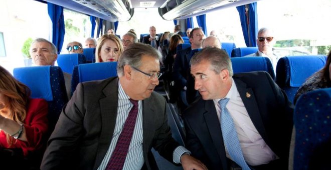 Fotografía facilitada por el Ministerio del Interior del titular del Departamento, Juan Ignacio Zoido (i), conversando con Miguel Folguera, de la asociación Plataforma de apoyo a las víctimas, en el autocar que traslada a los representantes de asociacione