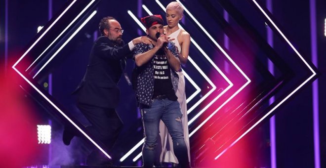 Momento en el que el espontáneo arrebata el micrófono a SuRie en plena actuación en Eurovisión. /EFE