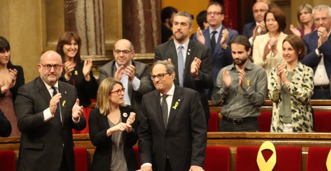 Quim Torra, al costat d'Elsa Artadi i Eduard Pujol, rep els aplaudiments dels diputats de JxCat, després de ser investit com a nou president de la Generalitat. / Parlament de Catalunya