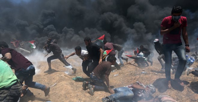 Un grupo de palestinos huyen y se tiran al suelo ante el fuego israelí en Gaza. /REUTERS