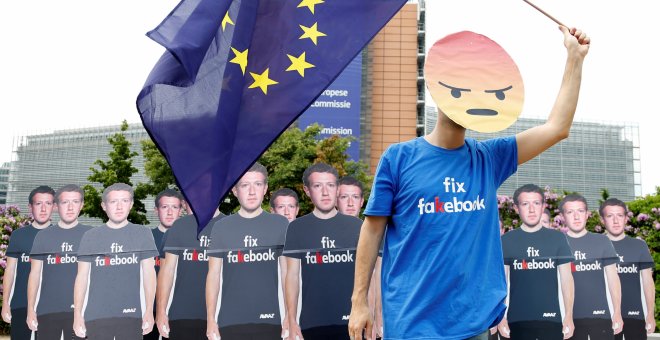 Un manifestante sostiene una bandera de la Unión Europea junto a efigies de cartón que representan al fuundador de Facebook, Mark Zuckerberg, durante una concentración antes de una reunión entre el empresario de Internet y los líderes del Parlamento Europ