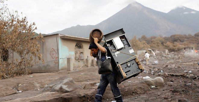 Un hombre recupera algunos objetos de su casa afectada por la erupción del Volcán de Fuego./REUTERS