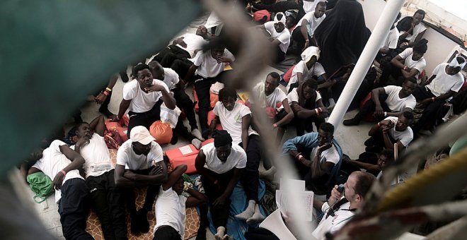 Los migrantes se sientan en la cubierta del 'MV Aquarius', el barco de búsqueda y rescate de Médicos sin Fronteras y SOS Mediterranee en el Mediterráneo. REUTERS