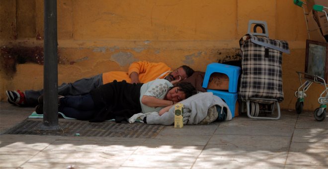 Personas sin hogar duermen en una calle de Málaga. - REUTERS