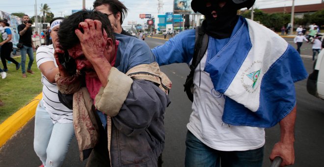 Varios manifestantes inmovilizan a uno de los supuestos paramilitares que han abierto fuego contra los asistentes a las marcha en Managua.- REUTERS/Oswaldo Rivas