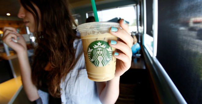 Una mujer sostiene una bebida en una cafetería Starbucks. / REUTERS - Mario Anzuoni