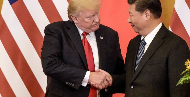 Donald Trump, a la izquierda, estrechando la mano del líder chino, Xi Jinping - FRED DUFOUR/AFP