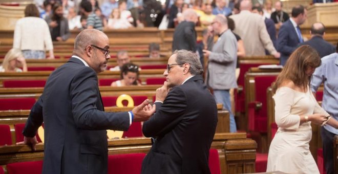 El presidente de la Generalitat de Cataluña, Quim Torra (d) y el conseller de Interior, Miquel Buch (i), esperan el inicio del pleno en el Parlament mientras la mesa continúa reunida para abordar el informe de los servicios jurídicos sobre el alcance del