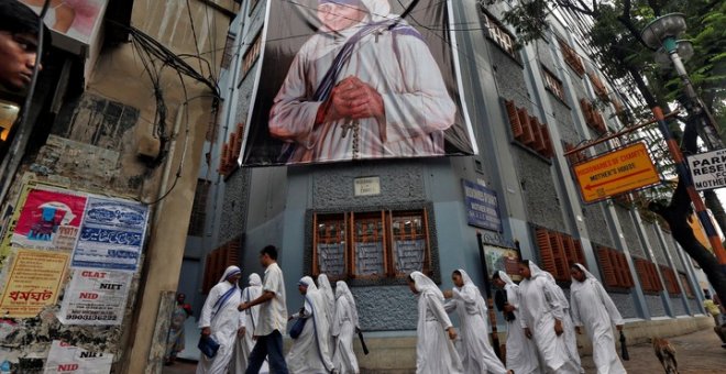 Monjas pertenecientes a las Misioneras de la Caridad pasan junto a una gran pancarta de la Madre Teresa - REUTERS